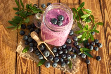 Yaban mersini tatlısı veya yaban mersini tatlısı ahşap arka planda taze berry ile smoothie. Üstte görüntü.