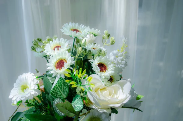 De nombreux bouquets de fleurs blanches avec de minces rideaux blancs — Photo