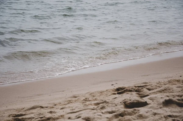 Die Meereswellen fegten auf den Sand am Strand. — Stockfoto