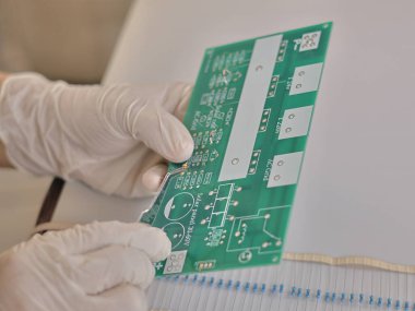 Close-up captures small parts using tweezers to assemble into pcb circuit board.