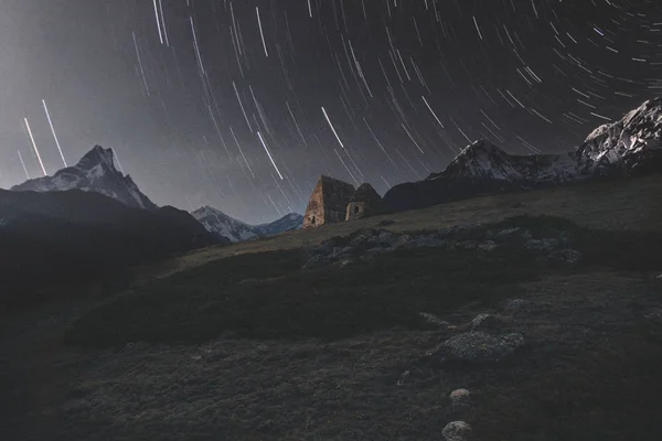 ancient ruins against the starry sky and snow-capped mountains