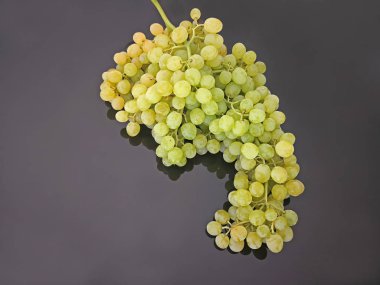 Siyah parlak arka planda tohumsuz sarı üzümler.