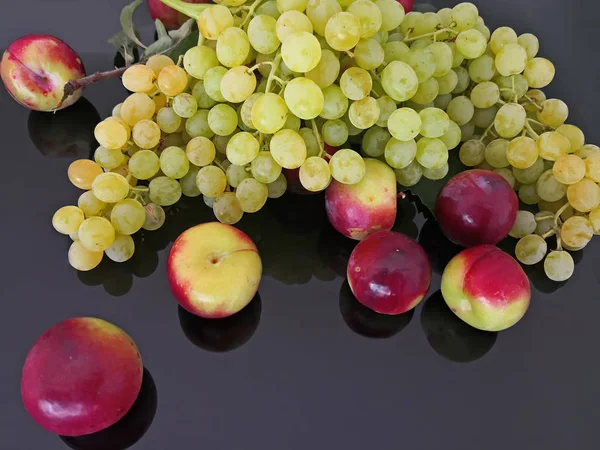 Vita Druvor Och Röda Plommon Svart Glas — Stockfoto