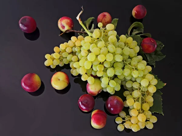 Białe Winogrona Czerwone Śliwki Czarnym Szkle — Zdjęcie stockowe