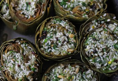 Tencere icerisinde pirinc, zeytin yagi, maydanoz ve cam fistigi karisimiyle doldurulmus Enginarlar