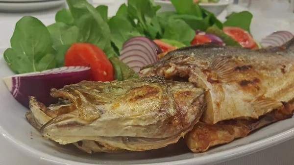 Pesce Branzino Con Patatine Fritte Pomodoro Cipolla Rossa Rucola Limone — Foto Stock