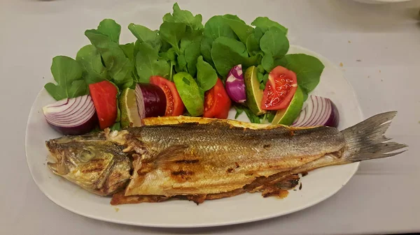 Wolfsbarsch Mit Pommes Tomaten Roten Zwiebeln Rucola Und Zitrone — Stockfoto