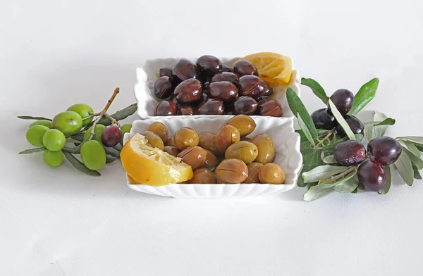 Black and green olives in bowl on white background.