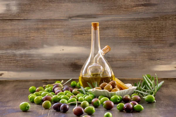 橄榄在木制背景上 瓶子里的橄榄油 — 图库照片