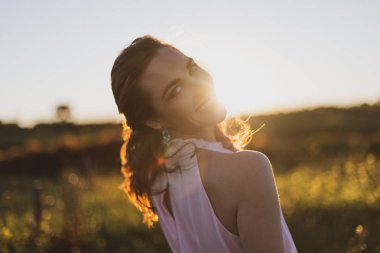 Gün batımında pembe yazlar elbiseli son derece mutlu kız portre çekim