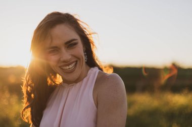 Gün batımında pembe yazlar elbiseli son derece mutlu kız portre çekim