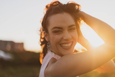 Gün batımında pembe yazlar elbiseli son derece mutlu kız portre çekim