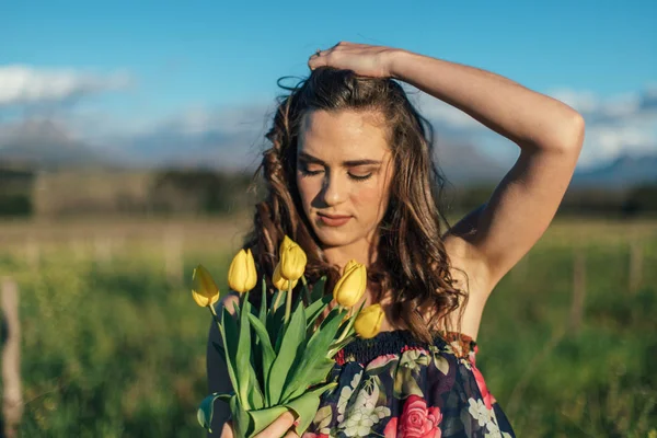Wanita Berambut Cokelat Cantik Lapangan Dengan Bunga Tulip Kuning — Stok Foto