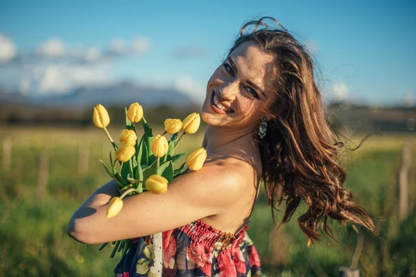 Sarı Lale Çiçek Alanıyla Güzel Esmer Kadın — Stok fotoğraf