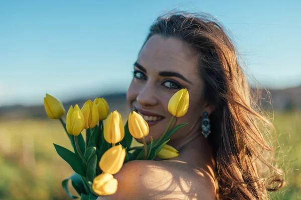 Sarı Lale Çiçek Alanıyla Güzel Esmer Kadın — Stok fotoğraf