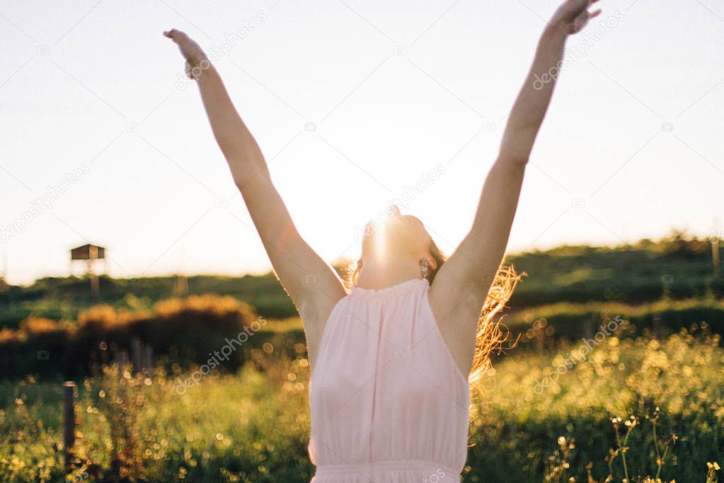 Pretty brunette women dancing at sunset in field