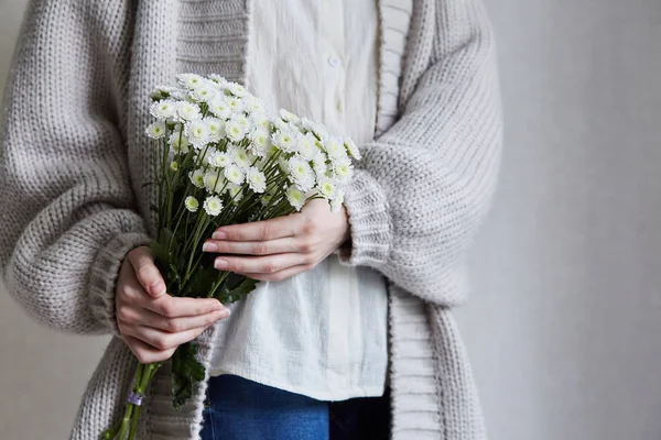 Foto einer jungen Frau mit weißen Blumen und grünem Stiel in der Hand — Stockfoto