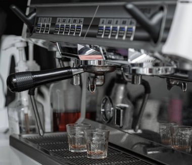 Kahve makinesi konsolu. Paslanmaz çelik paslanmaz çelik makine yakın çekim. Kahve makinesinin kolu kahve sıvıyı damlıyor. Şeffaf cam. Bu iş sonrası kahve makinesinin durumu.