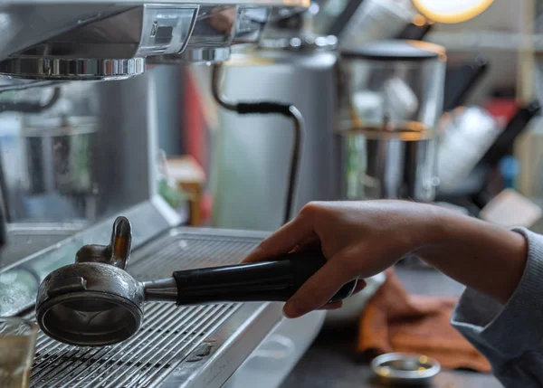 Barista aletleri temizliyor. Barista kahve konsolundaki kahve makinesi nin kolunu temizliyor..