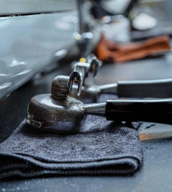 Mermer Masaüstü. Mavi temizleme bezi. Bir çift kahve makinesi kulpları. Soğuk ve sıcak renklerin karşılaştırılması. Sıcak ışık. Yakın çekim lens