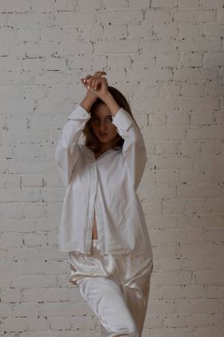 Moskova bir photoshoot Studio ile çekici kız. Hafif bir sabahlık beyaz renk bir photoshoot.