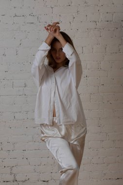 Moskova bir photoshoot Studio ile çekici kız. Hafif bir sabahlık beyaz renk bir photoshoot.