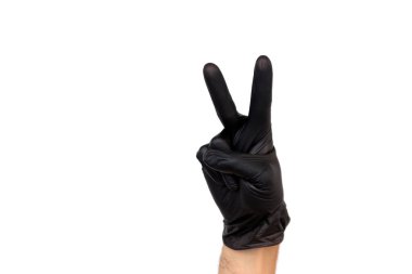 Beyaz bir arka plan üzerinde siyah lastik eldiven iki parmak gösteren el yalıtmak. Zafer jesti. Bir şef cerrah olarak başarılı çalışmalar kavramı veya temizleme