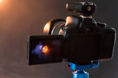 Stüdyoda bir profesyonel aydınlatma aygıtının duman Fotoğraflar mavi bir tripod üzerinde kamera fotoğraf. Stüdyo ışıkları ve duman ekipman. Fotoğraf makinesi ile radyo Eşitleyici
