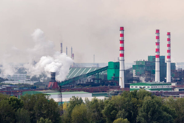 Угольный завод работает на берегу реки. Дым от труб загрязняет атмосферу города. Концепция загрязнения окружающей среды, выбросов в водные ресурсы
. 