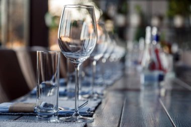 Garson, cam şarap restoran ve su bardağı, çatal ve bıçak Tekstil peçete üzerinde üst üste gri bir ahşap masa üzerinde durmak. Kavram ziyafet, Doğum günü, konferans, Grup öğle yemeği