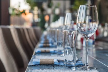 Garson, cam şarap restoran ve su bardağı, çatal ve bıçak Tekstil peçete üzerinde üst üste gri bir ahşap masa üzerinde durmak. Kavram ziyafet, Doğum günü, konferans, Grup öğle yemeği