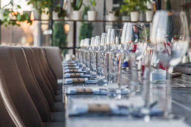 Garson, cam şarap restoran ve su bardağı, çatal ve bıçak Tekstil peçete üzerinde üst üste gri bir ahşap masa üzerinde durmak. Kavram ziyafet, Doğum günü, konferans, Grup öğle yemeği