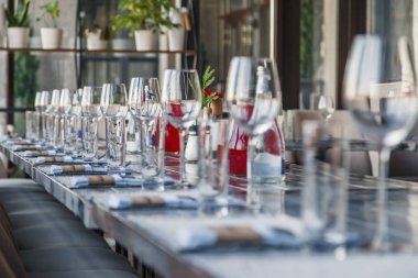 Garson, cam şarap restoran ve su bardağı, çatal ve bıçak Tekstil peçete üzerinde üst üste gri bir ahşap masa üzerinde durmak. Kavram ziyafet, Doğum günü, konferans, Grup öğle yemeği