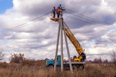 Rusya, Kemerovo, 15.10.2018. Takım kask ve üniformaları onarım güç hatları sarı Asansör hava platform alanının arka plan kamyona monte elektrikçi. Tehlikeli, yüksek voltaj kavramı