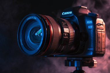 Rusya, Novosibirsk, 29 Ekim 2018. Profesyonel bir kamera bir tripod üzerinde siyah bir arka plan ve beyaz ve renkli duman Studio'da üzerinde Close-up. Konsept fotoğraf çekimi video kaydı