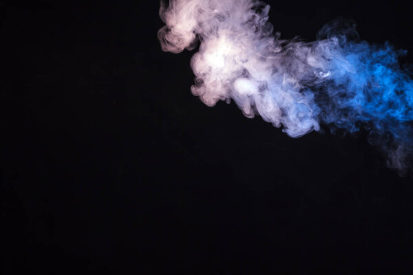 Colored smoke on a black background. The concept of a light show at a music concert