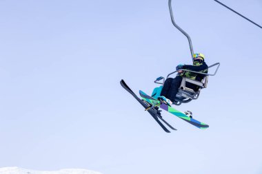 Rusya, Sheregesh 2018.11.17 snowboard ve profesyonel kıyafet tırmanış teleferik yukarı kayakçı dağların arka planda gökyüzü ve dağ doruklarına kaldırın. Kayak Emanet, açık dinlenme, dostluk kavramı