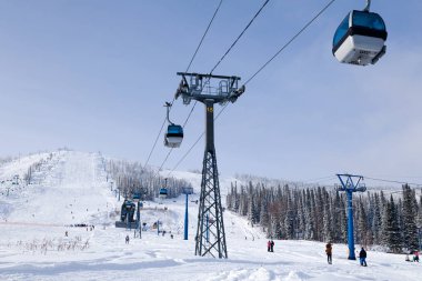 Ski lift, teleferik füniküler Vadisi, kayakçı, snowboard, karla kaplı dağlar, yaprak dökmeyen ağaçlar arka plan üzerine açık kabinli. Alpler resort, Georgia, Soçi, Matterhorn kavramı
