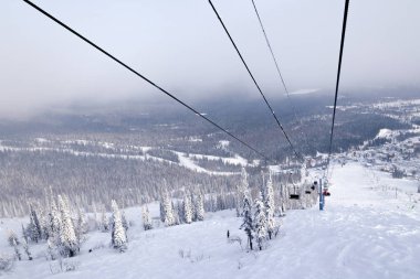 Ski lift, teleferik füniküler Vadisi, kayakçı, snowboard, karla kaplı dağlar, yaprak dökmeyen ağaçlar arka plan üzerine açık kabinli. Alpler resort, Georgia, Soçi, Matterhorn kavramı