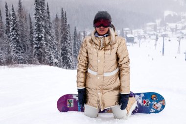 Rusya, altın spor giyim Sheregesh 2018.11.18 kız snowboard ve karlı yüksek dağlar ve orman kıyafeti. Kavram dinlenme apres Kayak