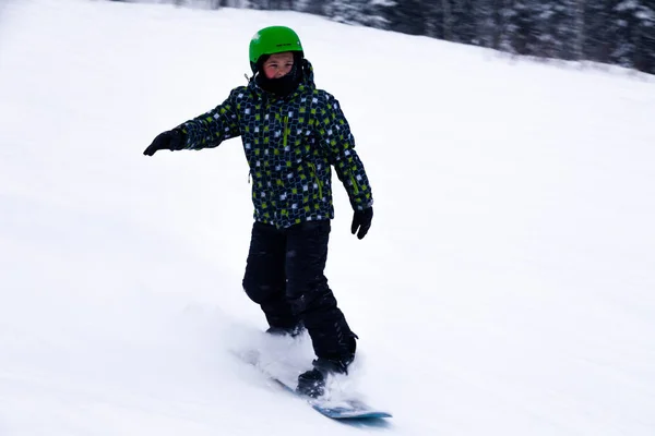 俄罗斯 谢雷格什2018 儿童滑雪者在明亮的运动服和服装和头盔滑雪下坡在雪阳光明媚的高山 软聚焦 物体在运动 安全运动的概念 — 图库照片