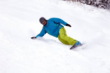 Rusya, Sheregesh 2018.11.18 profesyonel snowboard parlak spor giyim ve yokuş aşağı karlı güneşli yüksek dağlarda at binme kıyafeti. Bulanıklık, yumuşak odak, nesne hareket. Kavram freeride, tehlike spor