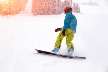 Rusya, Sheregesh 2018.11.18 profesyonel snowboard parlak spor giyim ve yokuş aşağı karlı güneşli yüksek dağlarda at binme kıyafeti. Bulanıklık, yumuşak odak, nesne hareket. Kavram freeride, tehlike spor