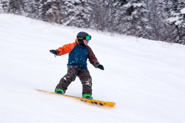 Rusya, Sheregesh 2018.11.18 profesyonel snowboard parlak spor giyim ve yokuş aşağı karlı güneşli yüksek dağlarda at binme kıyafeti. Bulanıklık, yumuşak odak, nesne hareket. Kavram freeride, tehlike spor