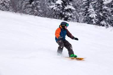 Rusya, Sheregesh 2018.11.18 profesyonel snowboard parlak spor giyim ve yokuş aşağı karlı güneşli yüksek dağlarda at binme kıyafeti. Bulanıklık, yumuşak odak, nesne hareket. Kavram freeride, tehlike spor