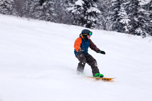 Rusya, Sheregesh 2018.11.18 profesyonel snowboard parlak spor giyim ve yokuş aşağı karlı güneşli yüksek dağlarda at binme kıyafeti. Bulanıklık, yumuşak odak, nesne hareket. Kavram freeride, tehlike spor