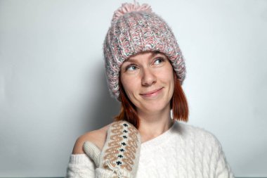 İzole portre güzel genç Kızıl saçlı kız yeşil gözleri desen mittens kürk ponpon, pembe örgü şapka Studio beyaz arka plan üzerinde yana giyinmiş ile kazak, beyaz. Moda dergisi vurdu kavramı