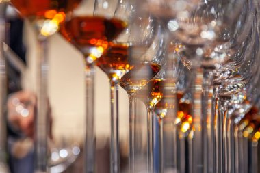 Profesyonel adam cavist içki dükkanında konyak raf ile şarap kadehi alır. Degüstasyon ruhları kavramı: viski, konyak, ROM, şeri, porto, barmenler rekabet acı