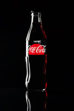 Rusya Kemerovo 13-12-2018 Closeup şişe Coca Cola güzel parlama ile siyah arka plan üzerine camdan yansıyan. Tatlılar ve gazlı içecekler, diyet, bağımlılık kavramı Coca Cola lossbottle bir güzel siyah bir zemin üzerine ağırlık