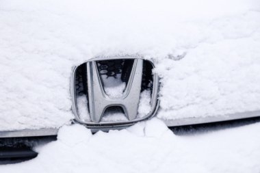 Rusya Kemerovo 2018-12-23 yakın çekim metal amblem marka simgesi Honda Stepwgn pofuduk karla kaplıdır. Sibirya kuzey havası, tipi, kar yağışı ve soğuk sert koşulları hesaba katın